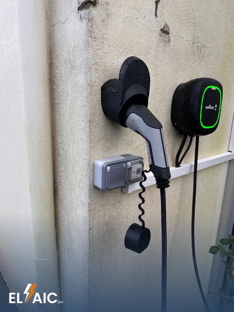 Borne de recharge Wallbox pour véhicule électrique installée en façade extérieure à Pleyben